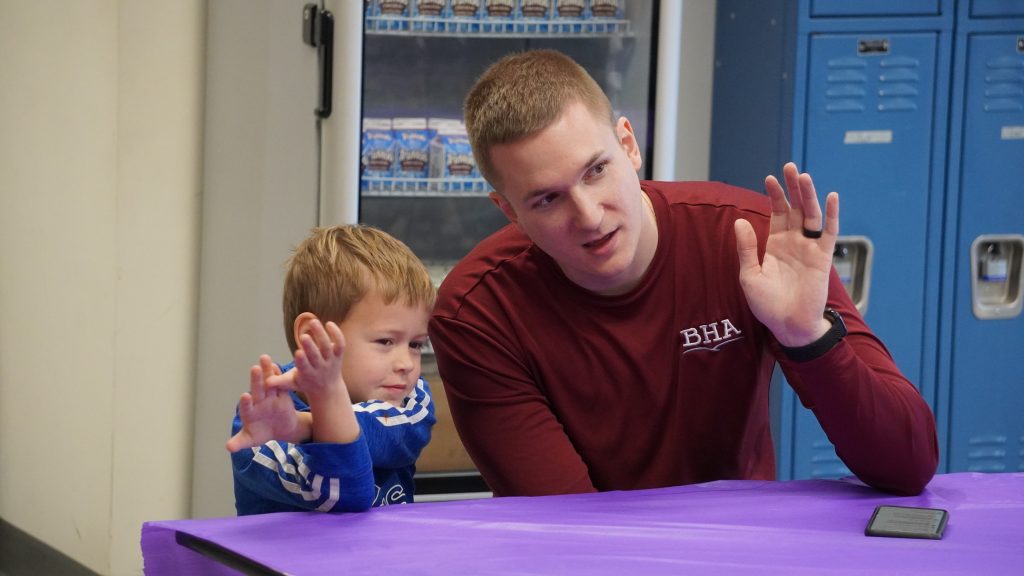 Man, right, speaks with boy student, left, encouraging him